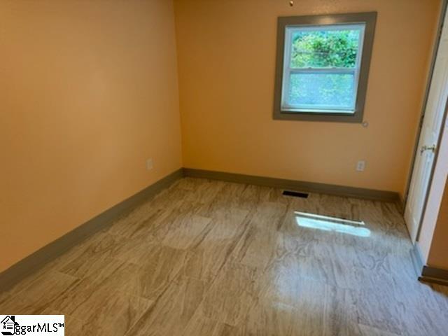 empty room with light hardwood / wood-style flooring