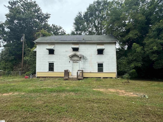 back of property with a lawn