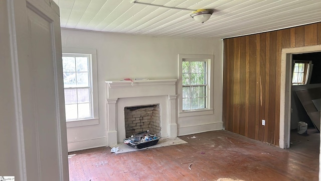 unfurnished living room with wood walls and a wealth of natural light