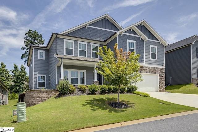 craftsman inspired home featuring board and batten siding, stone siding, driveway, and a front lawn