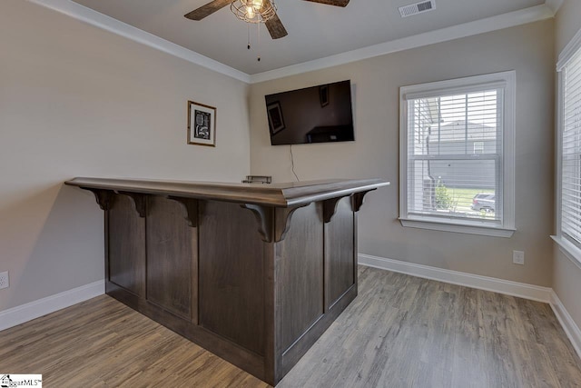 bar featuring ornamental molding, visible vents, light wood-style flooring, and baseboards