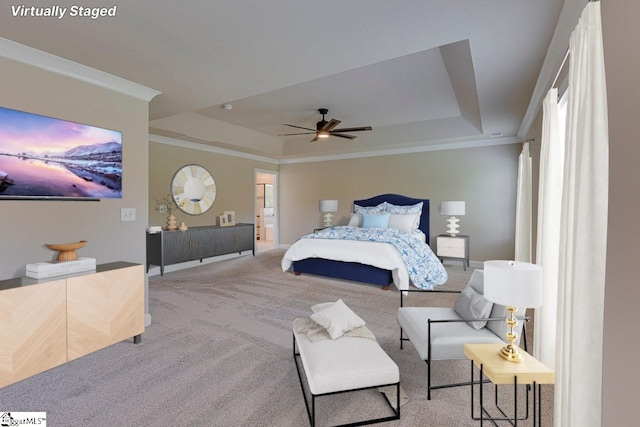 bedroom with a ceiling fan, a tray ceiling, light colored carpet, and crown molding