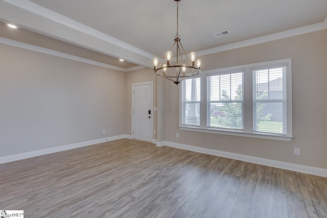 spare room featuring baseboards, beam ceiling, visible vents, and wood finished floors