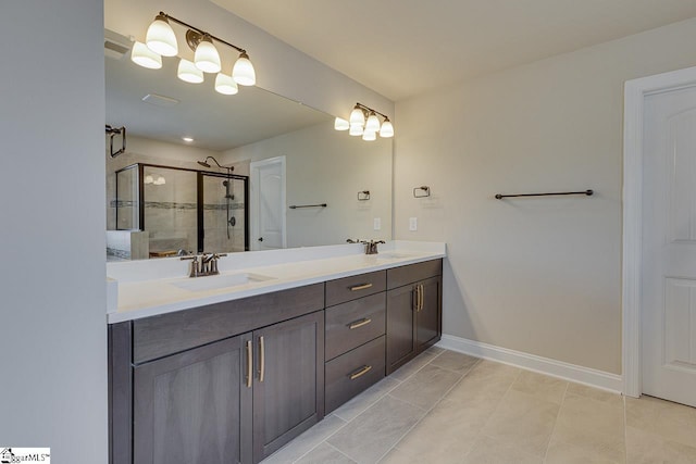 bathroom featuring double vanity, a shower stall, baseboards, and a sink