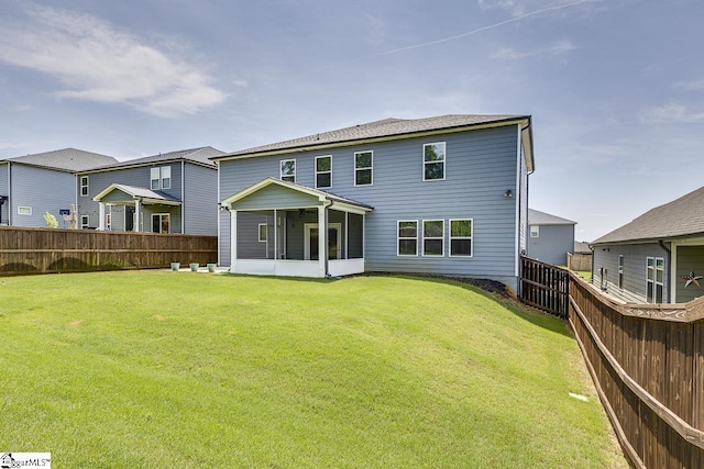 back of house with a sunroom, a fenced backyard, and a yard