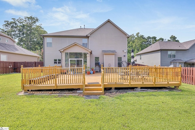 rear view of house featuring a yard and a deck