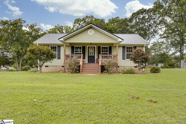 ranch-style home featuring a front lawn and covered porch