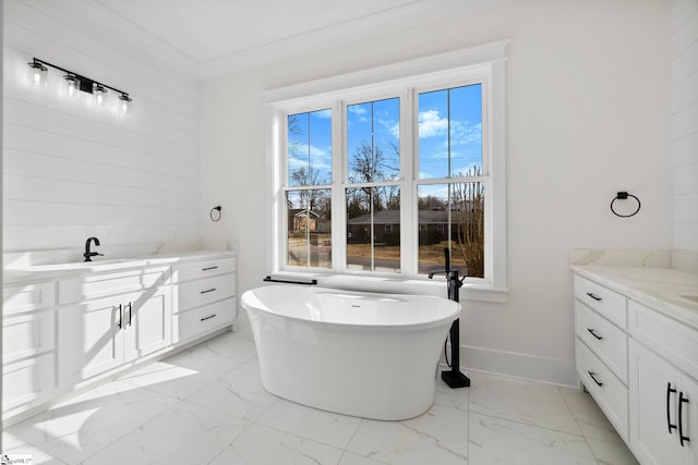 bathroom with vanity, a bathtub, and ornamental molding