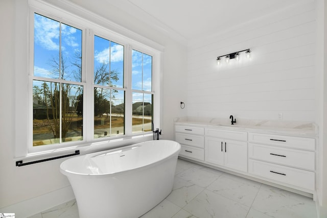 bathroom with a water view, vanity, crown molding, and a tub