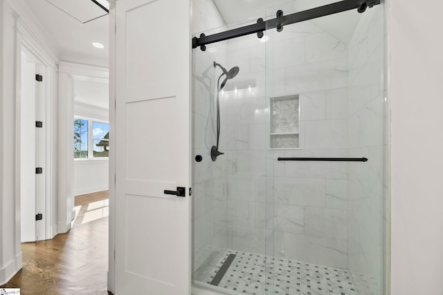 bathroom with hardwood / wood-style flooring and a shower with door