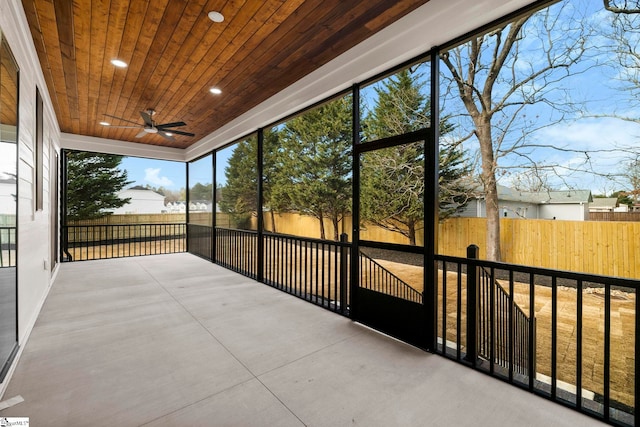 unfurnished sunroom with wood ceiling and ceiling fan