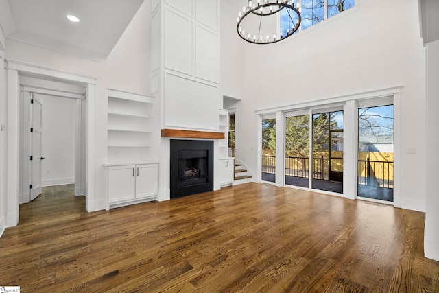 1 Mapleton Dr, Greenville, SC 29607 - unfurnished living room featuring built in features, wood finished floors, a chandelier, a fireplace, and baseboards