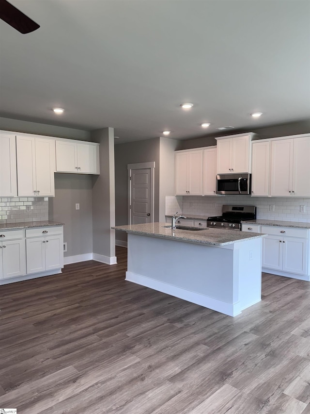 kitchen with sink, white cabinetry, an island with sink, stainless steel appliances, and light hardwood / wood-style floors