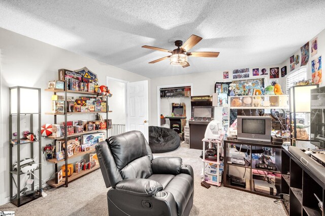 sitting room featuring a textured ceiling, light colored carpet, and ceiling fan