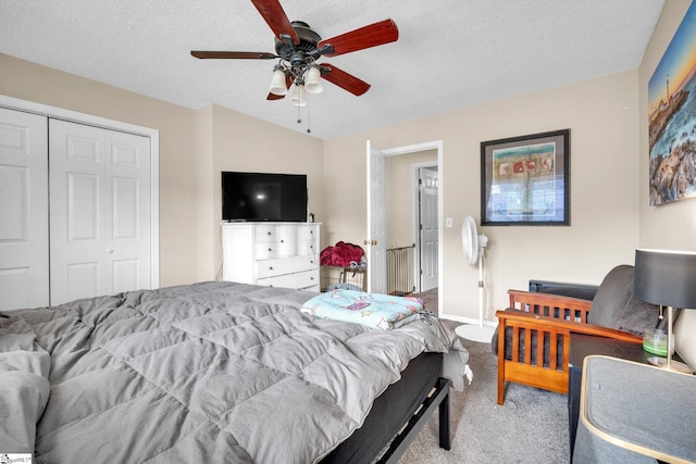 carpeted bedroom with a textured ceiling, a closet, and ceiling fan