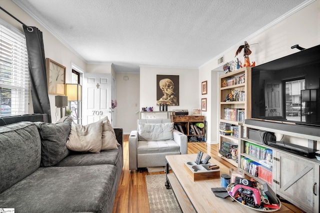 living room featuring crown molding, a textured ceiling, and hardwood / wood-style flooring