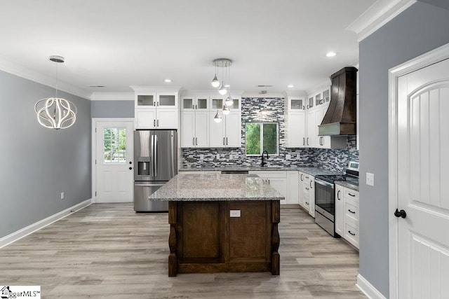 kitchen with decorative backsplash, appliances with stainless steel finishes, custom exhaust hood, crown molding, and a sink