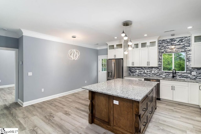 kitchen featuring ornamental molding, appliances with stainless steel finishes, backsplash, and a sink