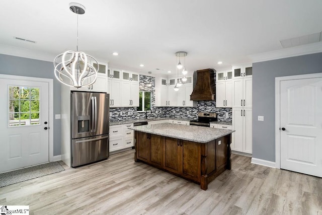 kitchen featuring visible vents, an inviting chandelier, stainless steel appliances, premium range hood, and backsplash