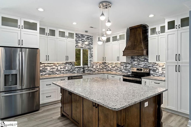 kitchen featuring custom exhaust hood, stainless steel appliances, backsplash, a sink, and a kitchen island