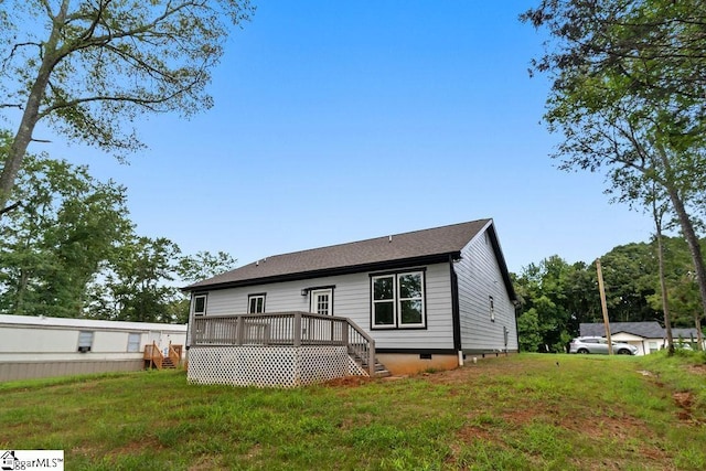 rear view of property featuring a yard and a deck