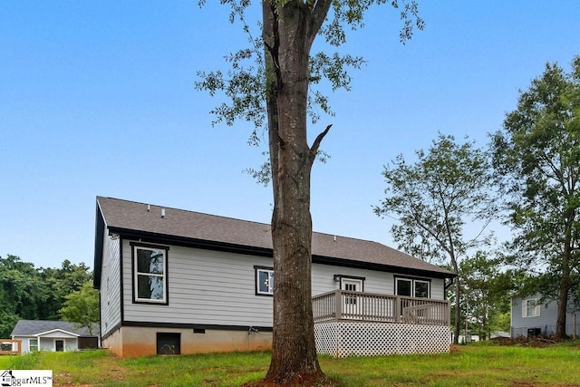 rear view of house featuring a yard and a deck