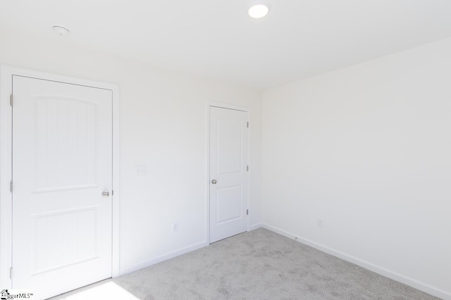 unfurnished room featuring light colored carpet