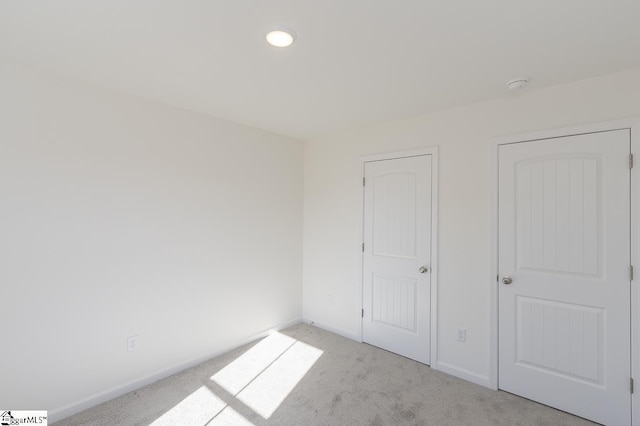 unfurnished bedroom featuring light carpet