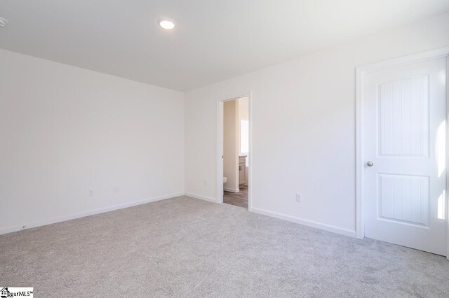 spare room featuring light colored carpet