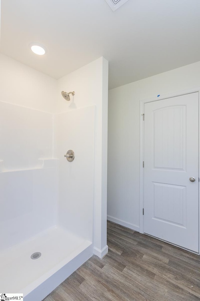 bathroom with hardwood / wood-style floors and walk in shower