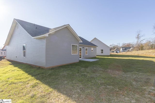 rear view of property with a lawn and a patio