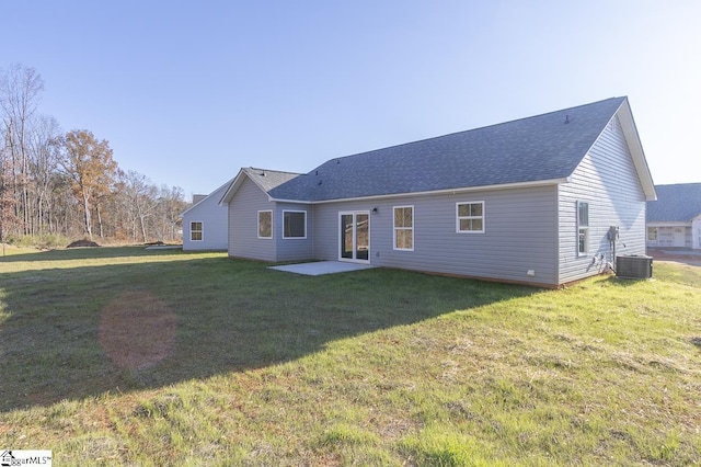 rear view of property featuring a lawn, cooling unit, and a patio