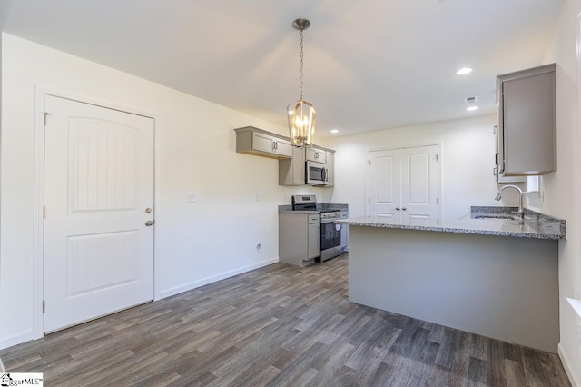 kitchen with dark hardwood / wood-style floors, sink, stainless steel appliances, and hanging light fixtures