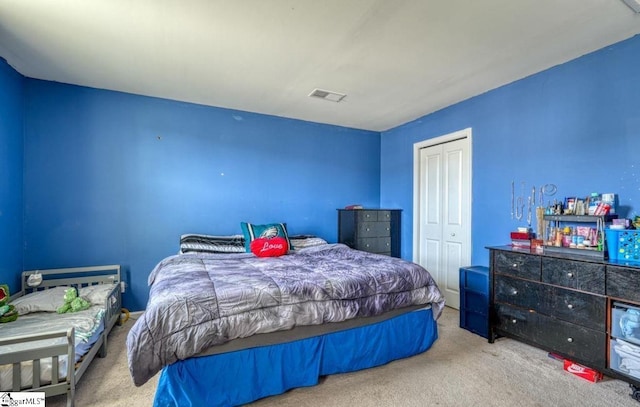 carpeted bedroom featuring visible vents and a closet