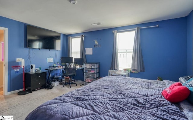 bedroom featuring multiple windows, visible vents, carpet floors, and baseboards