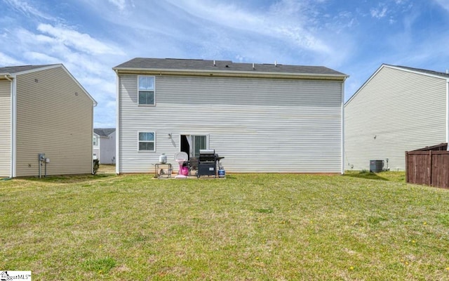 back of house featuring a lawn and central AC unit