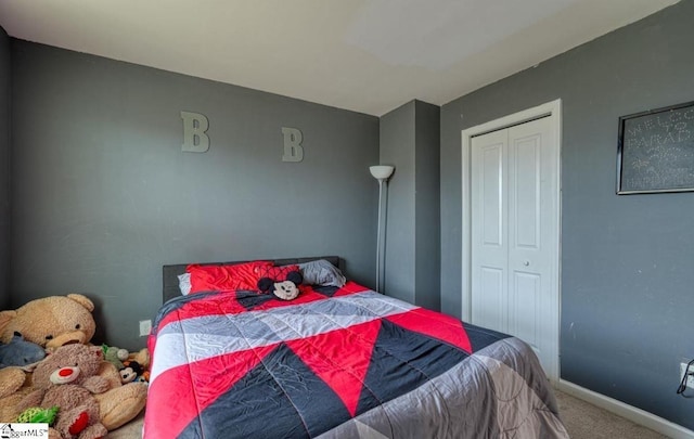 bedroom with baseboards, a closet, and carpet floors