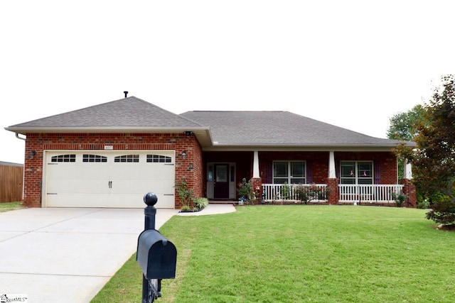 view of front of house featuring covered porch, a garage, and a front yard