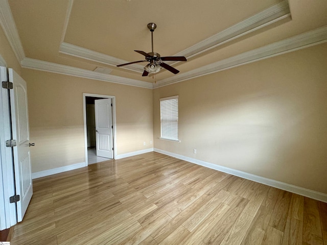 unfurnished bedroom with a raised ceiling, light hardwood / wood-style flooring, and ornamental molding