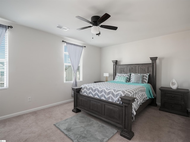 bedroom with multiple windows, light carpet, and ceiling fan