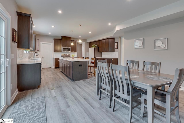 dining room featuring sink and light wood-type flooring