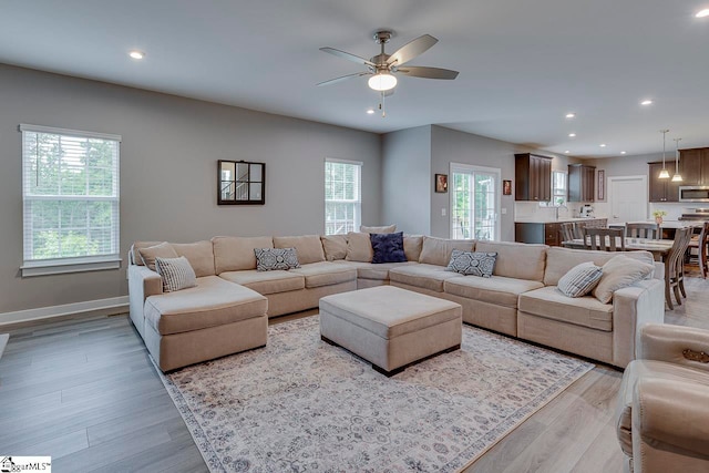 living room featuring light hardwood / wood-style floors and ceiling fan