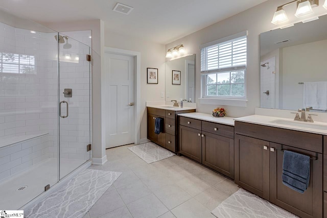 bathroom with tile patterned flooring, dual vanity, and a shower with shower door