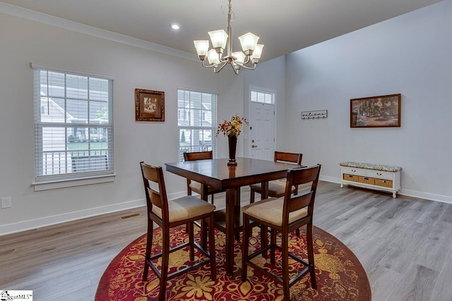 dining area featuring a wealth of natural light, crown molding, and light hardwood / wood-style floors