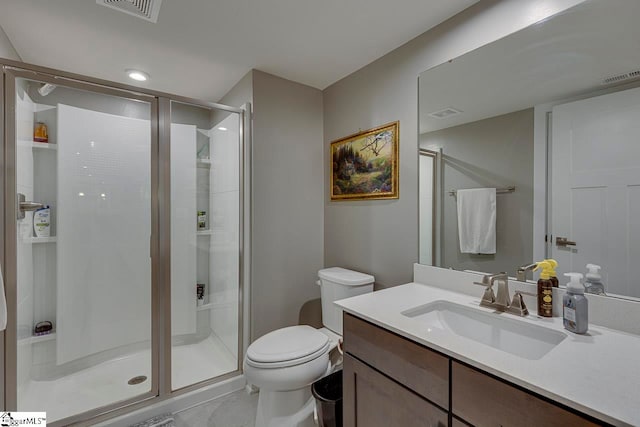 bathroom with tile patterned floors, vanity, a shower with door, and toilet