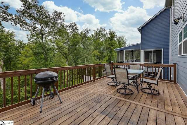 deck with a sunroom and grilling area