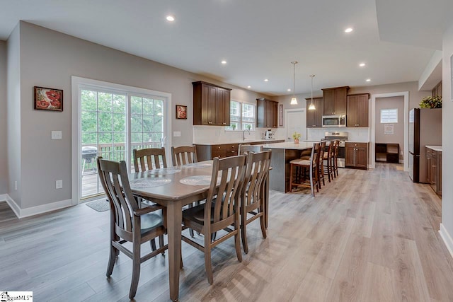 dining room featuring light hardwood / wood-style flooring, sink, and plenty of natural light