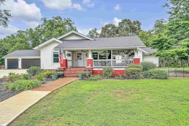 view of front of property featuring a porch, a garage, and a front lawn