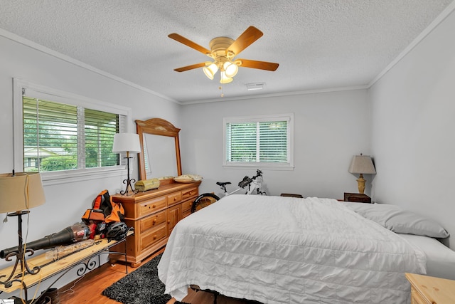 bedroom featuring multiple windows, ornamental molding, light wood-type flooring, and ceiling fan