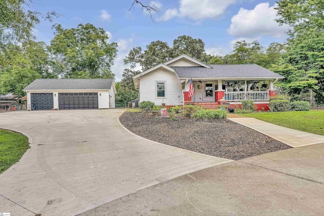 ranch-style house with a garage, covered porch, an outdoor structure, and a front lawn